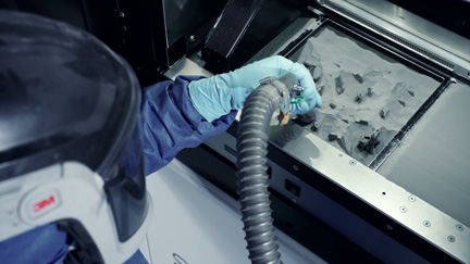 Operator uses suction wand to transfer powder using Volkmann pneumatic vacuum conveying system