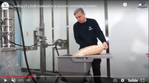 Un hombre carga un ingrediente a granel en un sistema de transporte neumático por vacío de Volkmann